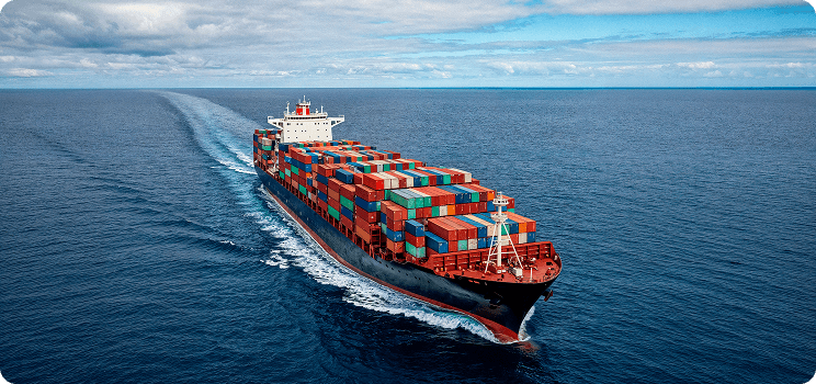 Cargo container vessel sailing across open ocean